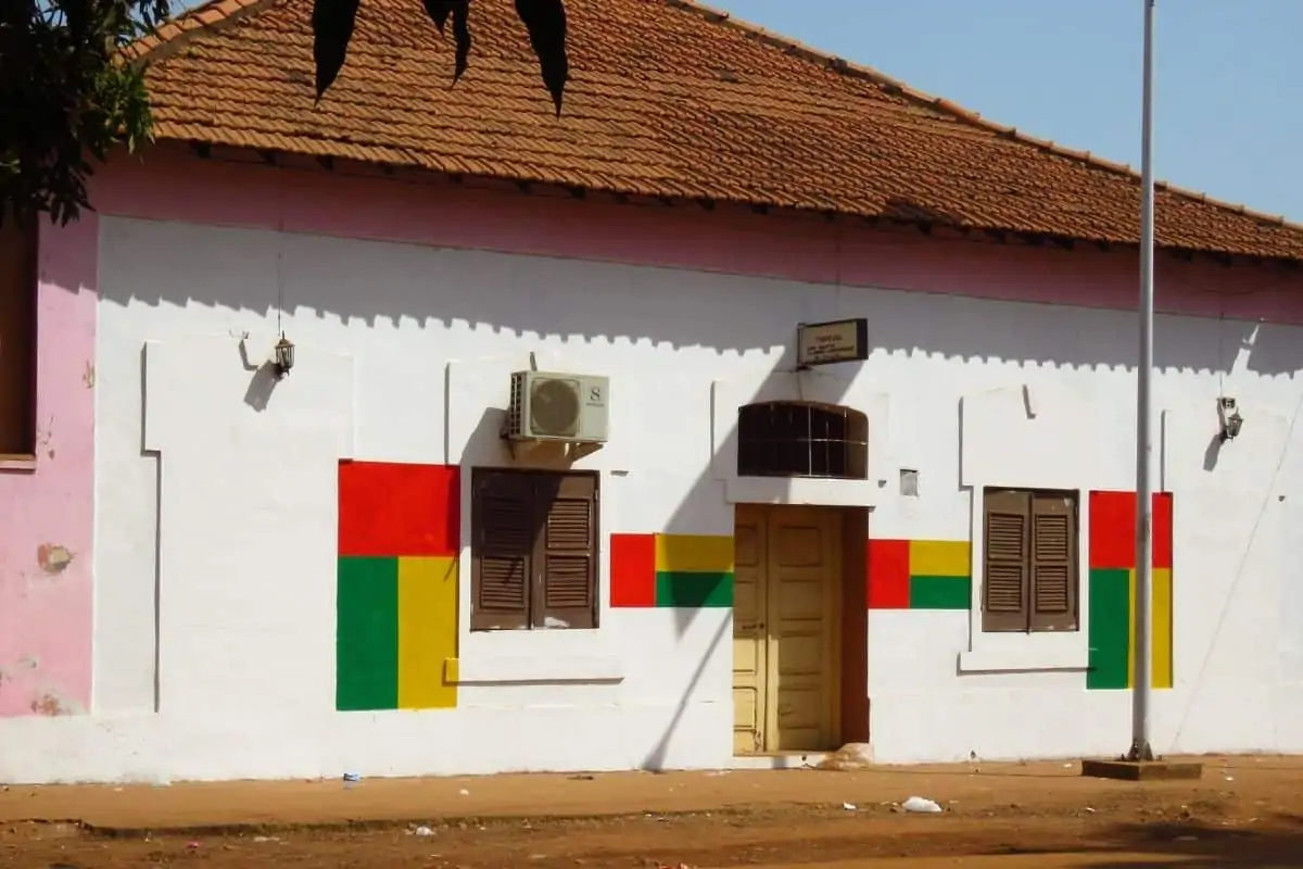 粉刷成白色的酒店，窗户旁边画着几内亚比绍国旗