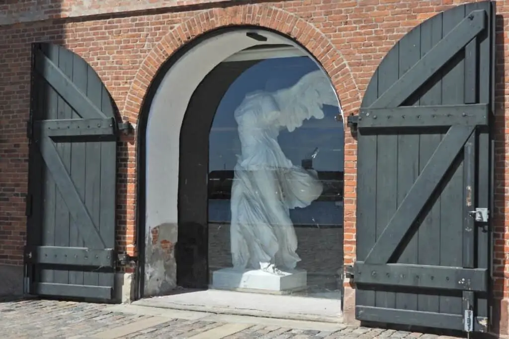 皇家铸造收藏与开放的拱形木百叶窗打开显示一个有翅膀的人物在里面