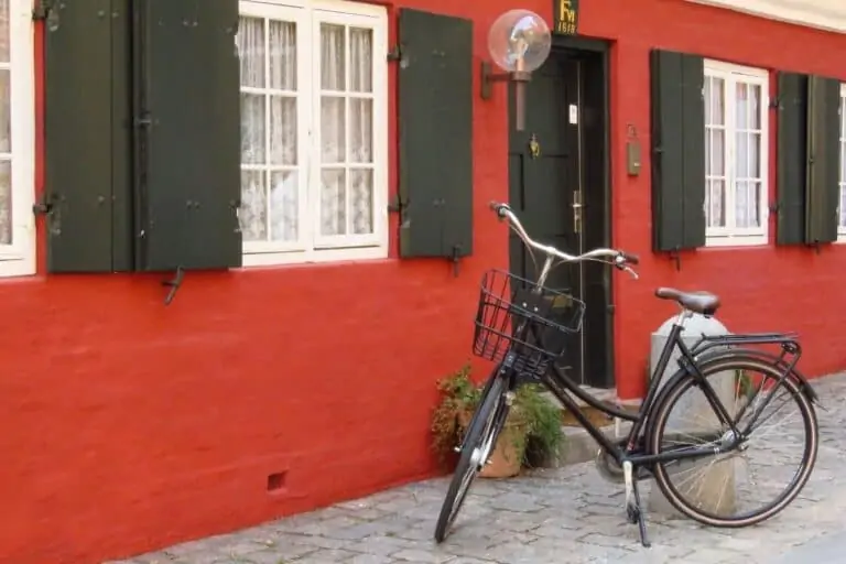一辆自行车与百叶窗画一个红色的房子外面