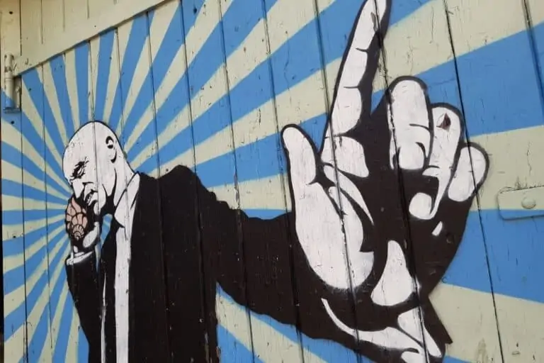 街头艺术的男人用手指在空中要求安静而说成壳!