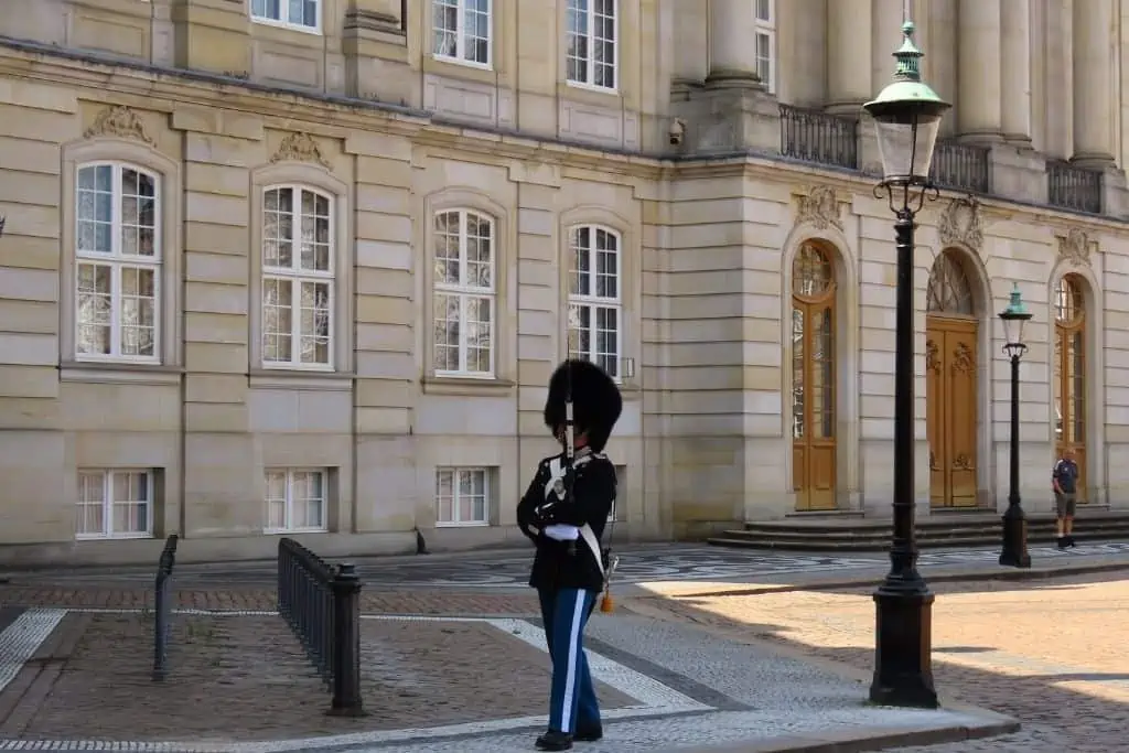 一名身穿全套制服和熊皮的警卫在哥本哈根阿马里安堡宫外行进。