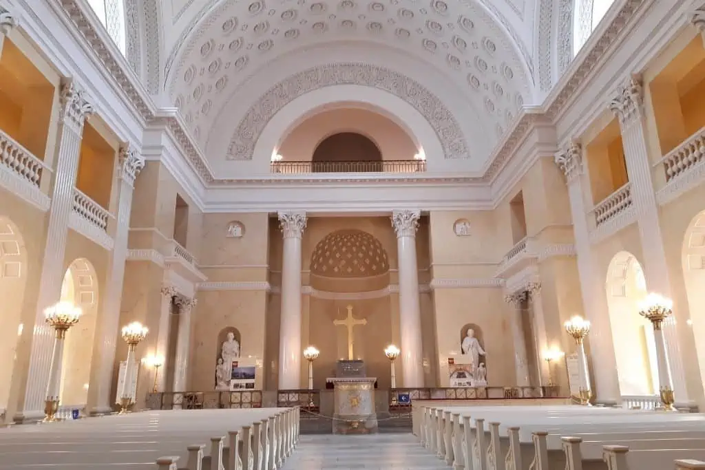 克里斯汀堡宫礼拜堂内部有一个圆顶祭坛，金色十字架和大理石雕像。