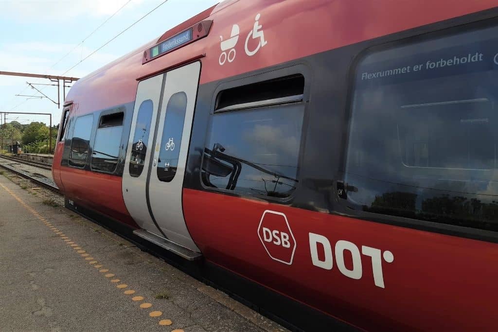 一辆红色的火车正在哥本哈根站的站台上等待。