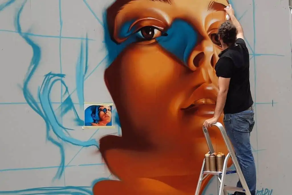哥本哈根街头艺术节上，一名街头艺术家用喷雾罐创造出一名女性的脸。