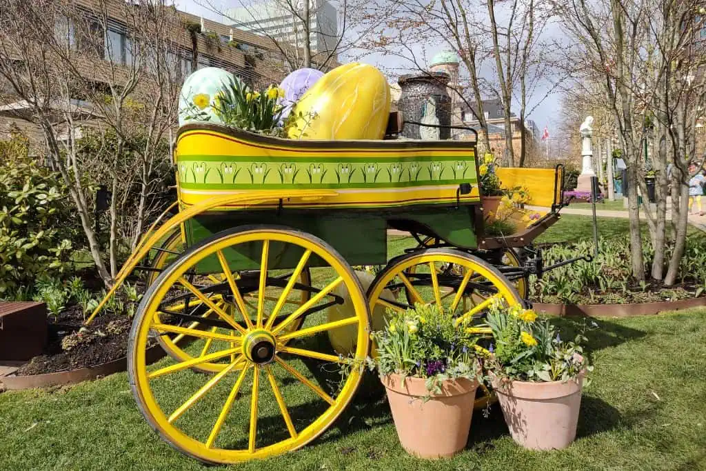 一个木制的,明亮的黄色车大,里面五颜六色的复活节彩蛋。