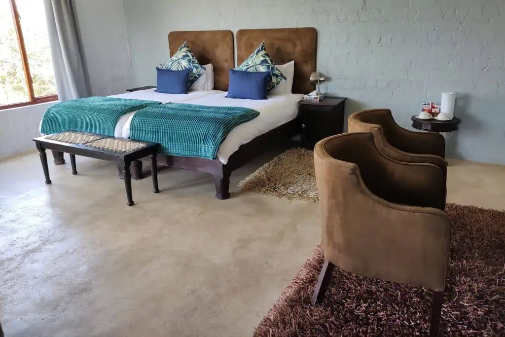 穿越河流旅馆的一个房间有两张单人床,两个棕色的扶手椅。