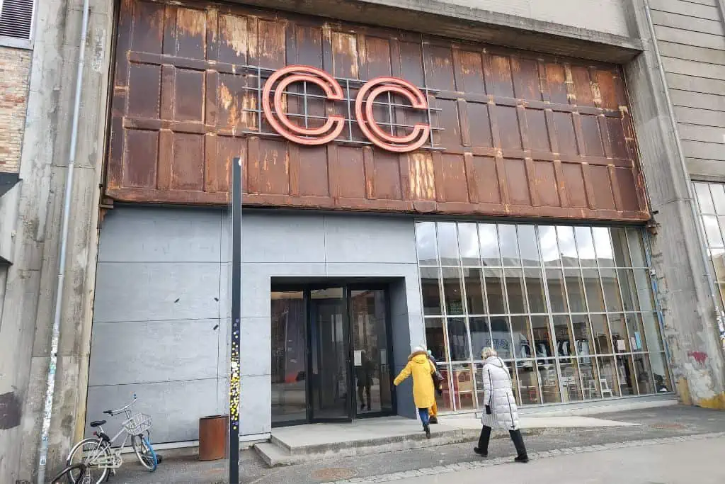 生锈的背景与哥本哈根当代的两个红色CC的标志在一个玻璃入口导致艺术画廊。