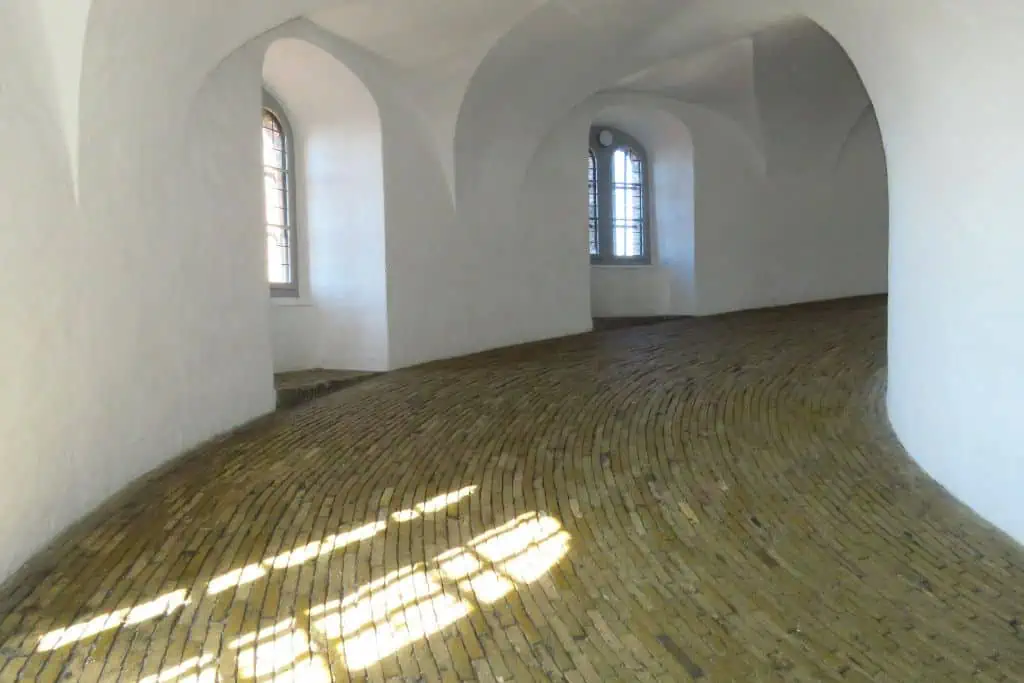 通过一个拱形的窗户太阳反射的鹅卵石在哥本哈根圆塔。